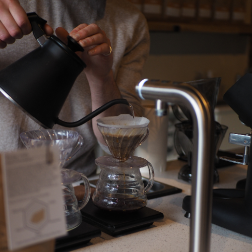An image of a woman pouring coffee