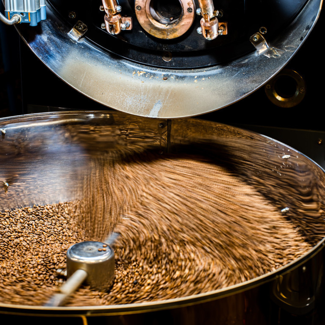 An image of coffee beans being mixed in a machine
